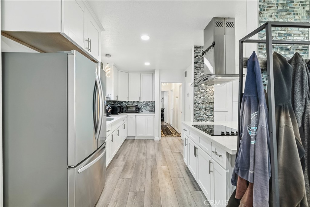 1349 Edgewood Way, Unit 49 Oxnard, CA 93030 - Photo 8 of 32 a kitchen with stainless steel appliances a refrigerator a sink and white cabinets