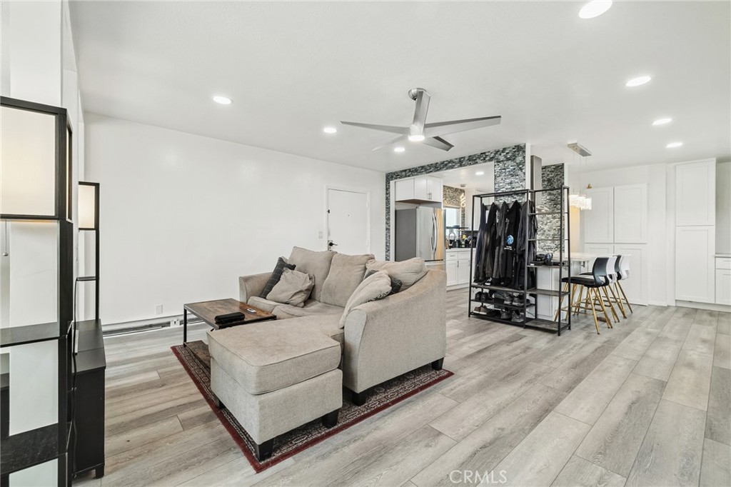 1349 Edgewood Way, Unit 49 Oxnard, CA 93030 - Photo 9 of 32 a living room with furniture a wooden floor and a fireplace