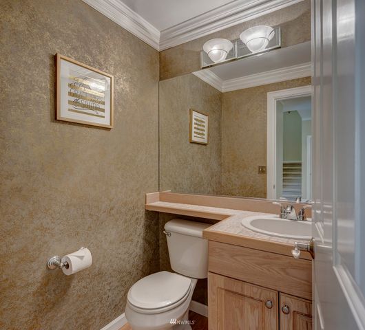 a bathroom with a toilet a sink and mirror