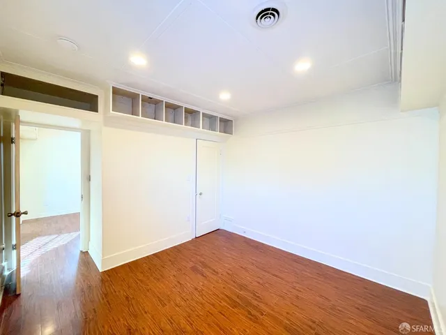 a view of empty room with wooden floor