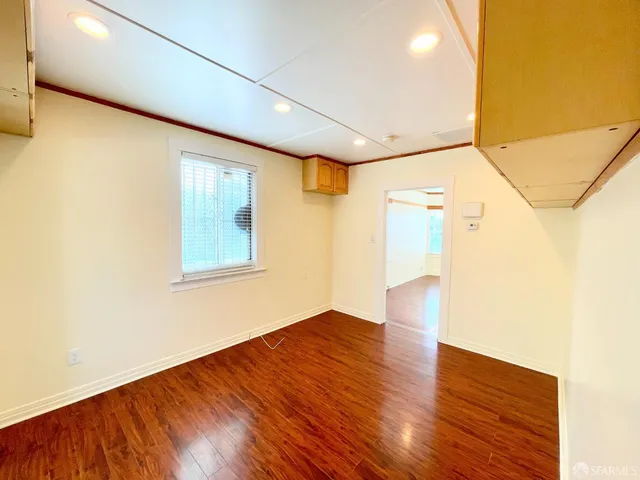a view of empty room with wooden floor