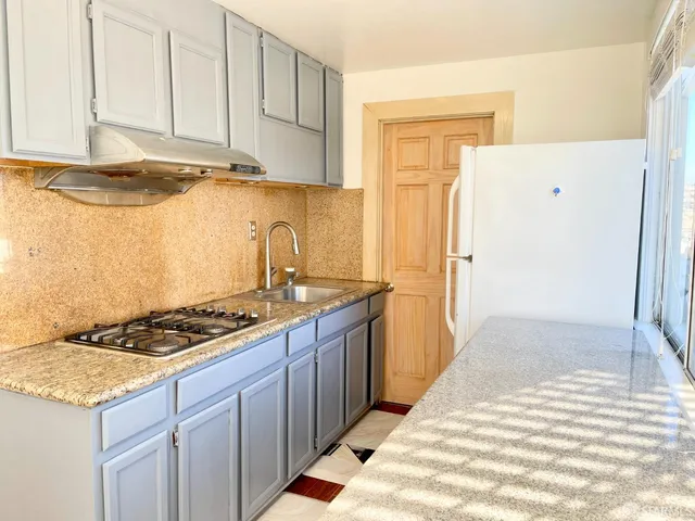 a kitchen with granite countertop cabinets and stove