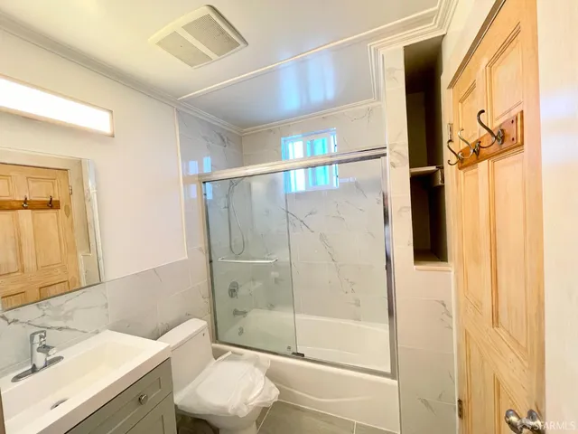 a bathroom with a granite countertop sink toilet and shower