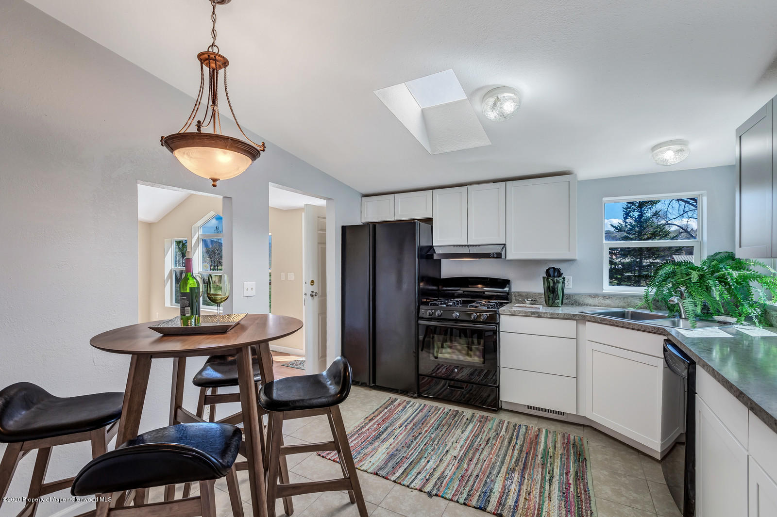 353 West 5th Street Rifle, CO 81650 - Photo 4 of 11 a kitchen with stainless steel appliances a dining table chairs and stove