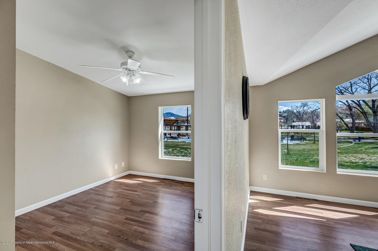 353 West 5th Street Rifle, CO 81650 - Photo 6 of 11 an empty room with wooden floor chandelier fan and windows