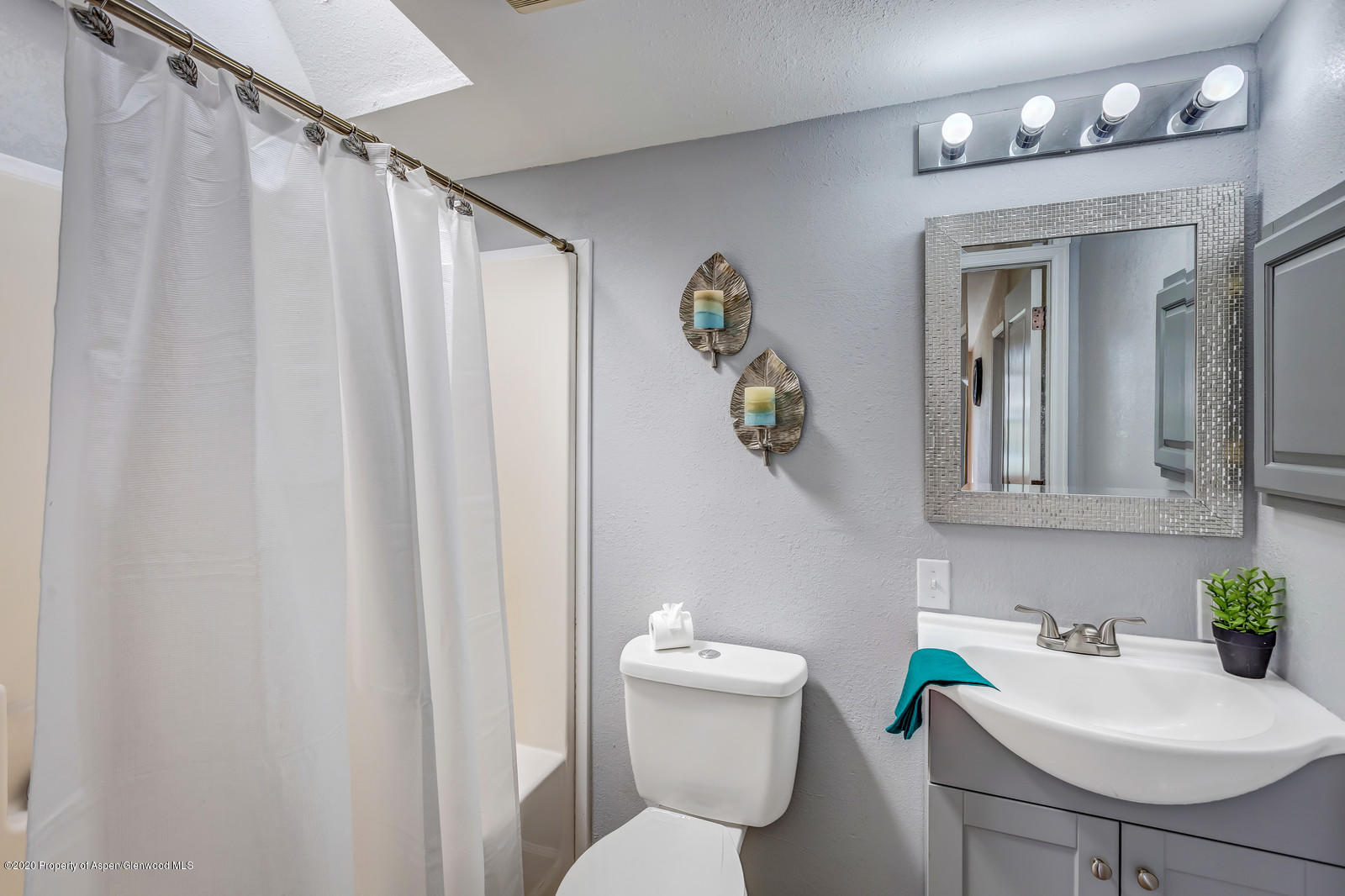 353 West 5th Street Rifle, CO 81650 - Photo 7 of 11 a bathroom with a sink mirror and toilet