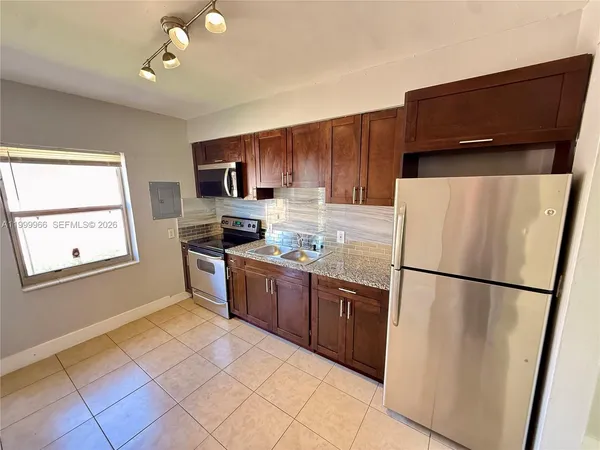 a kitchen with stainless steel appliances granite countertop a refrigerator a stove a sink dishwasher and a refrigerator
