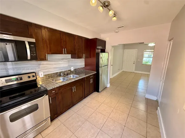 a kitchen with stainless steel appliances granite countertop a stove a sink and a refrigerator