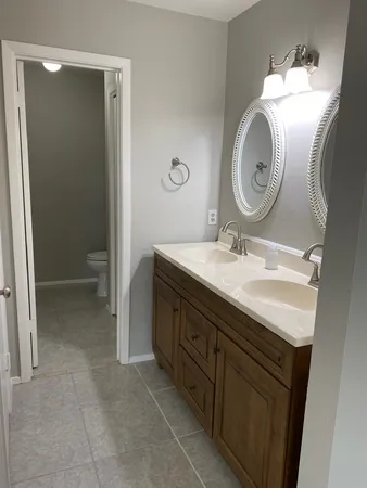 a bathroom with a granite countertop toilet and a bathtub