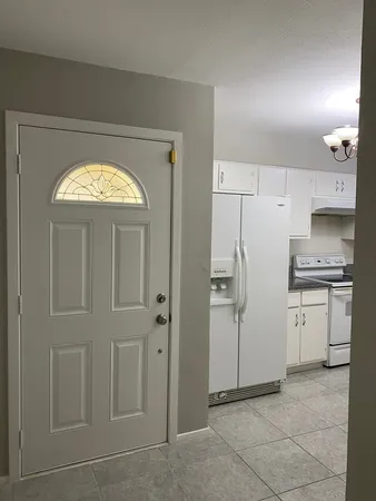 a view of kitchen with refrigerator and window