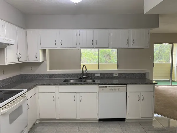 a kitchen with granite countertop white cabinets and a sink
