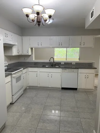a white kitchen with a sink and dishwasher