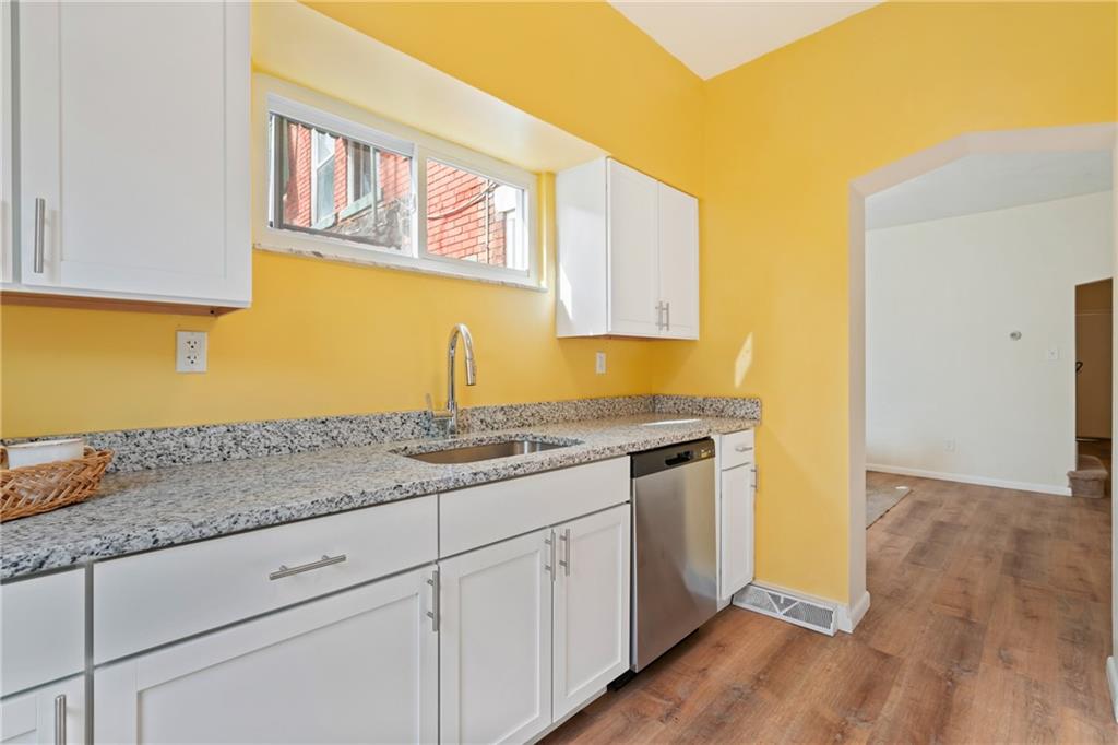 9 Edith Place Pittsburgh, PA 15213 - Photo 12 of 25 a kitchen with stainless steel appliances granite countertop a sink and dishwasher with wooden floor