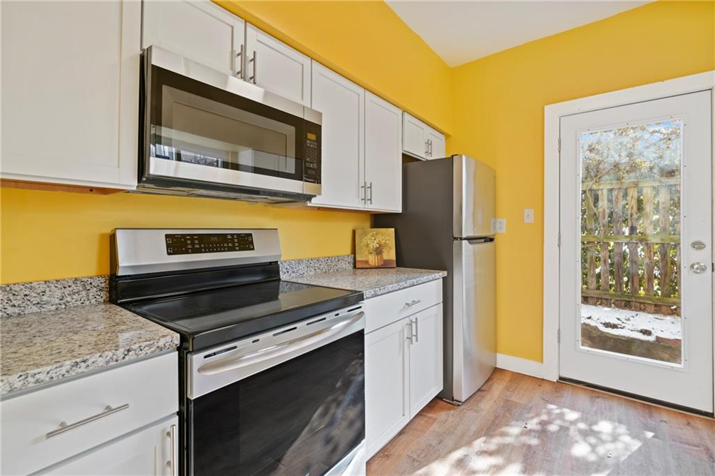 9 Edith Place Pittsburgh, PA 15213 - Photo 10 of 25 a kitchen with stainless steel appliances granite countertop a stove microwave and refrigerator
