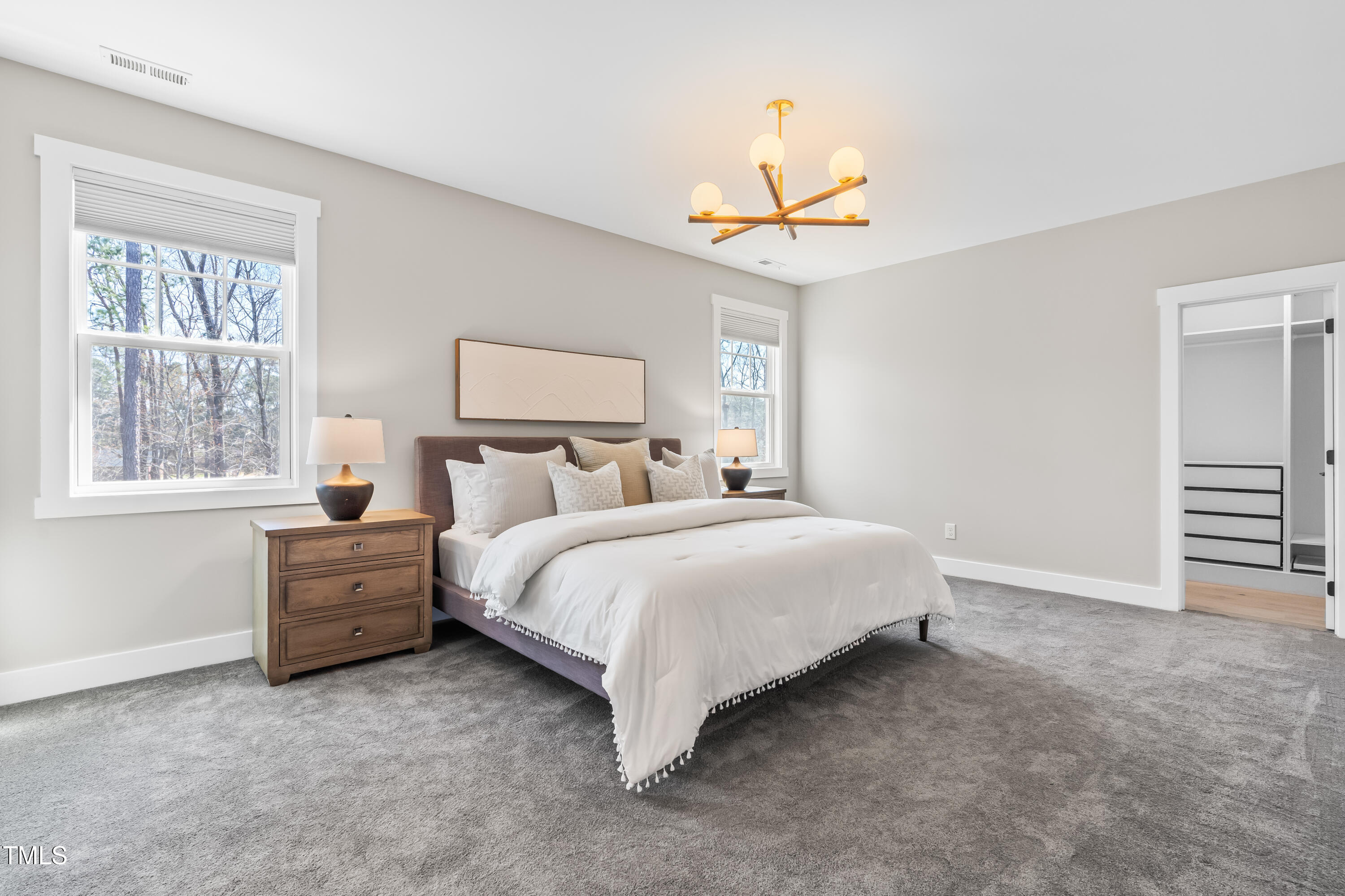 409 Tintern Lane Apex, NC 27523 - Photo 25 of 62 a spacious bedroom with a bed and a chandelier