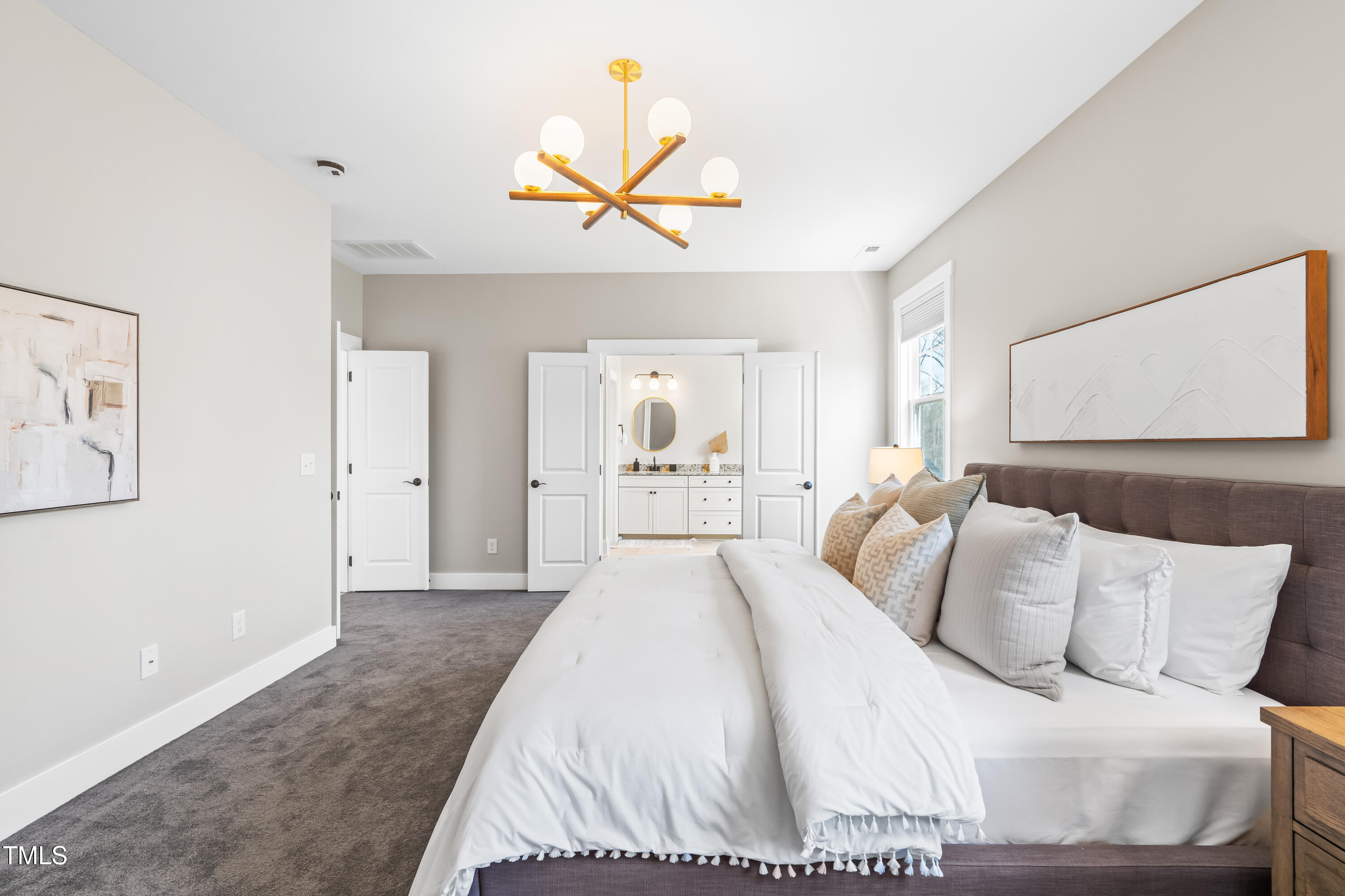 409 Tintern Lane Apex, NC 27523 - Photo 28 of 62 a bedroom with a large bed and a chandelier