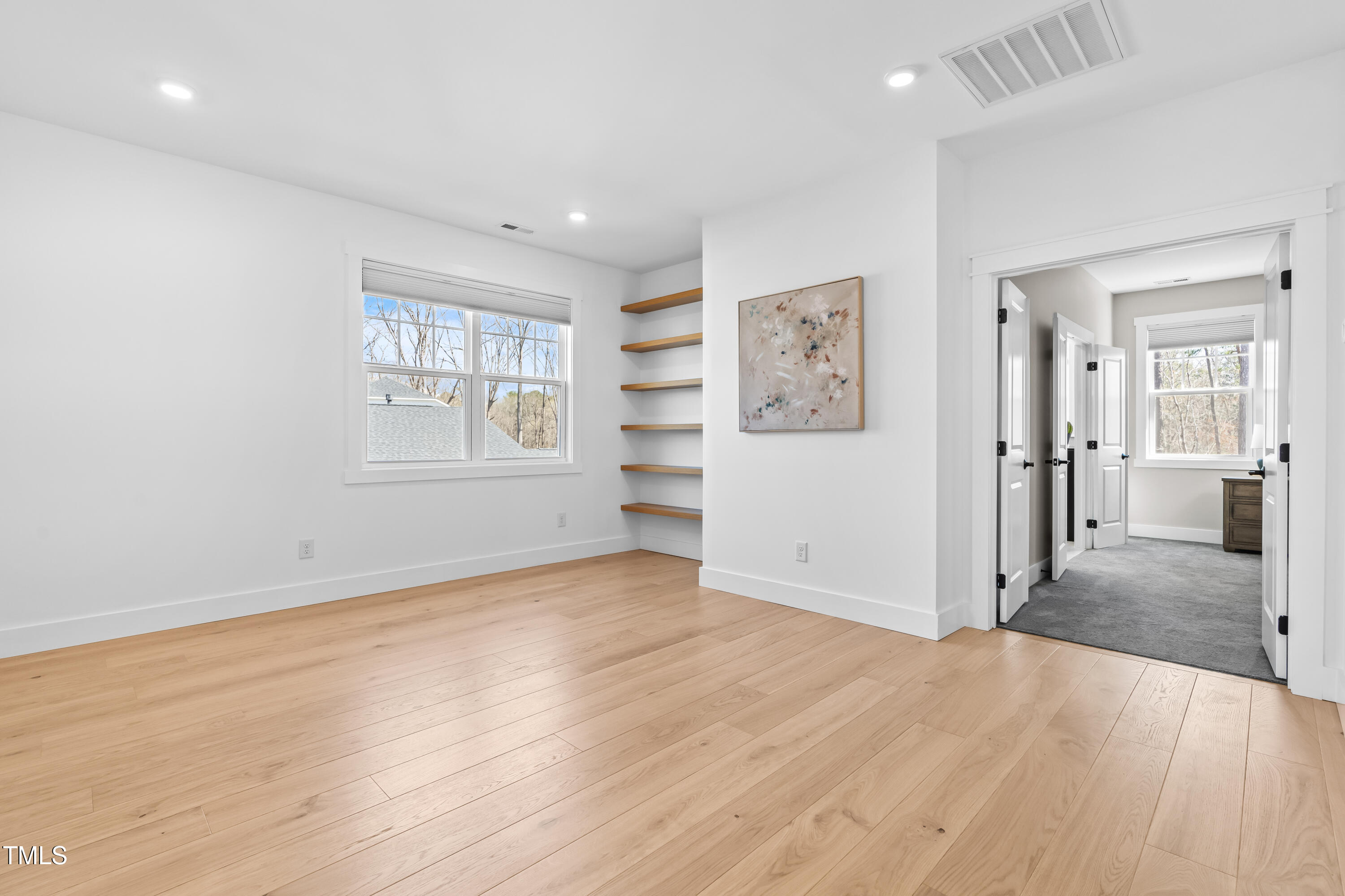 409 Tintern Lane Apex, NC 27523 - Photo 32 of 62 an empty room with wooden floor and windows