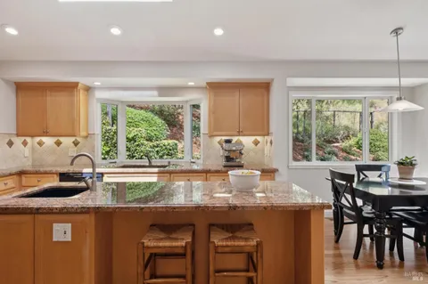 a kitchen with stainless steel appliances granite countertop a sink stove refrigerator and cabinets