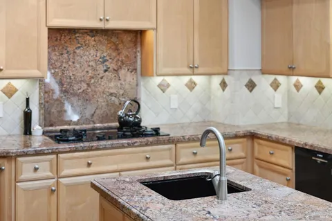 a kitchen with granite countertop a refrigerator stove and sink
