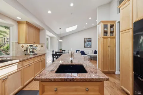 a kitchen with stainless steel appliances granite countertop a sink refrigerator and cabinets