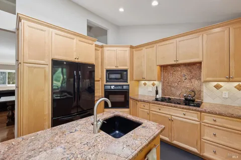 a kitchen with stainless steel appliances granite countertop sink refrigerator and microwave
