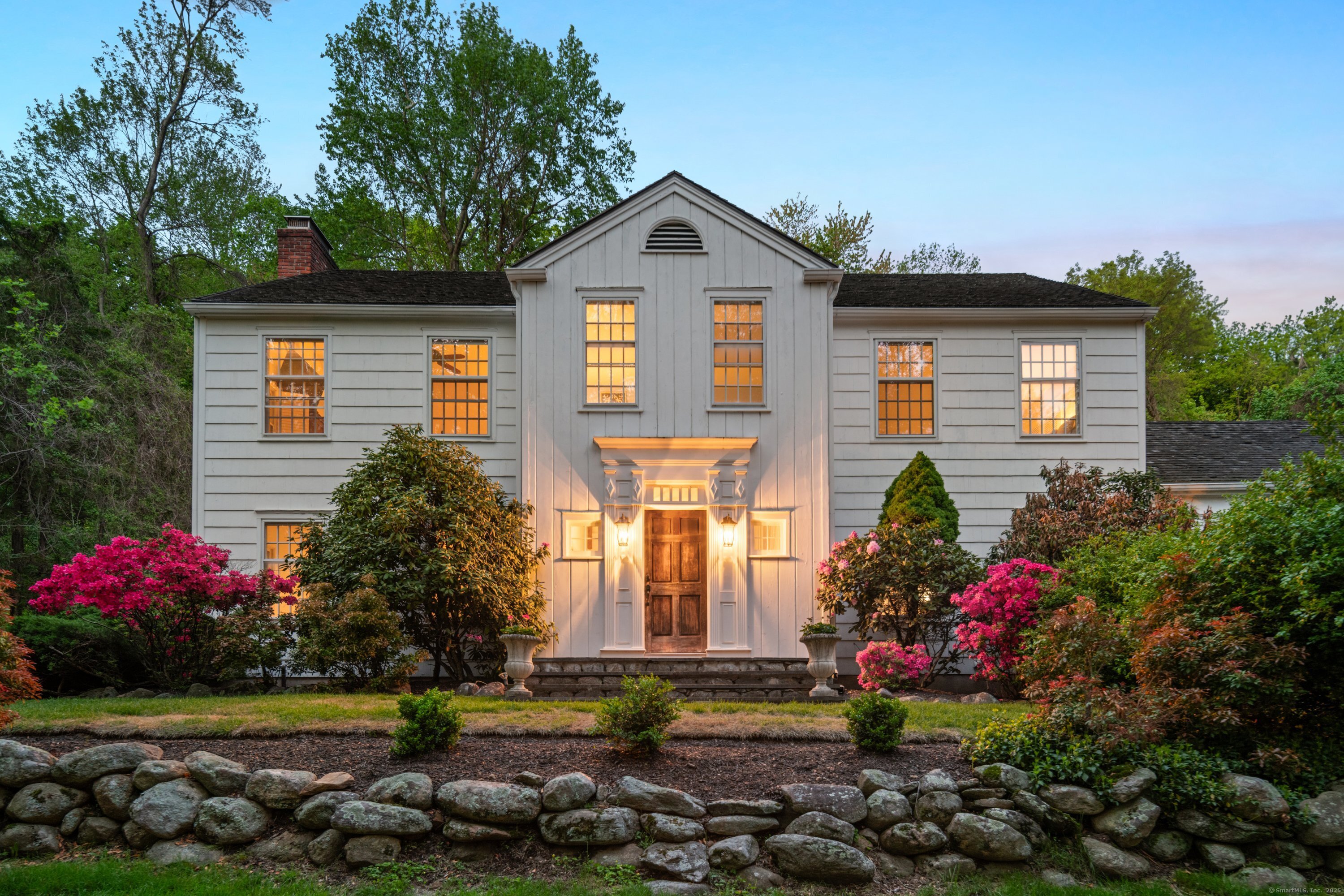 a front view of a house with a yard and potted plants
