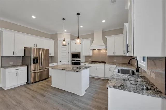 a kitchen with a refrigerator a sink and wooden floor