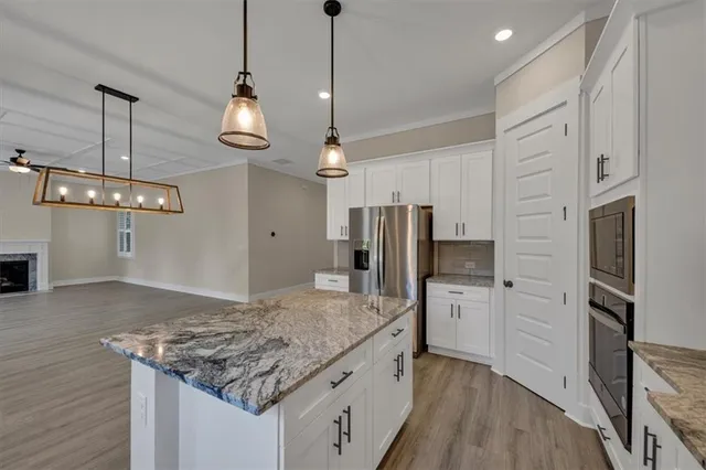 a kitchen with stainless steel appliances granite countertop a refrigerator a sink and a stove