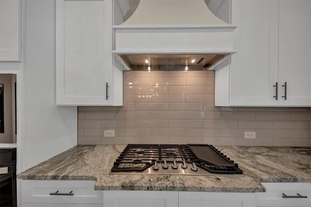 a kitchen with granite countertop a stove and cabinets