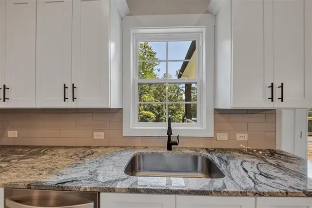 a kitchen with granite countertop a sink and a window