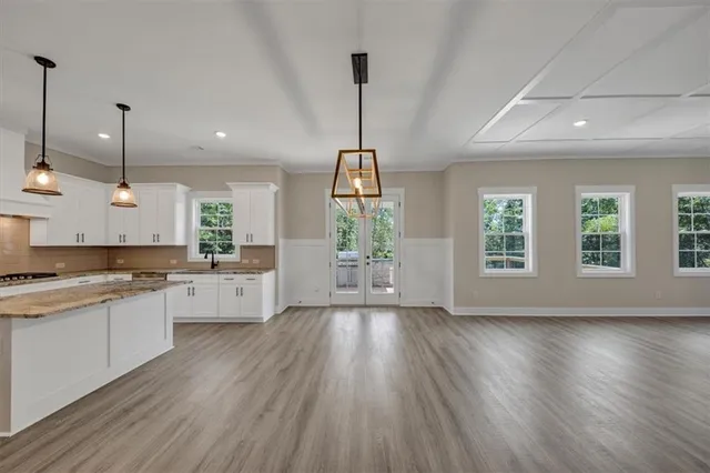 a large kitchen with lots of counter space a sink appliances and wooden floor