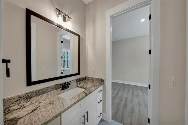 a bathroom with a granite countertop sink and a mirror