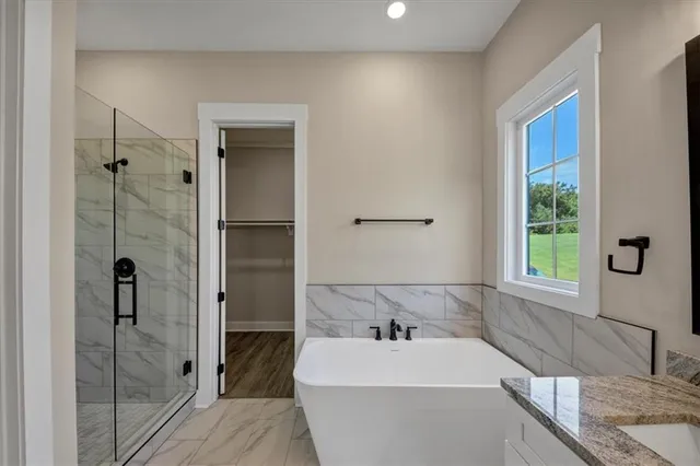 a bathroom with a tub sink and mirror