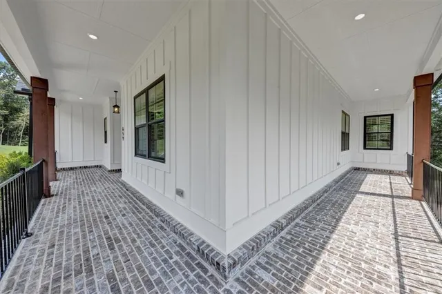 a view of a hallway with wooden floor and a living room
