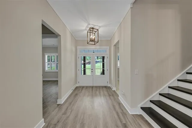 a view of a hallway with wooden floor and staircase