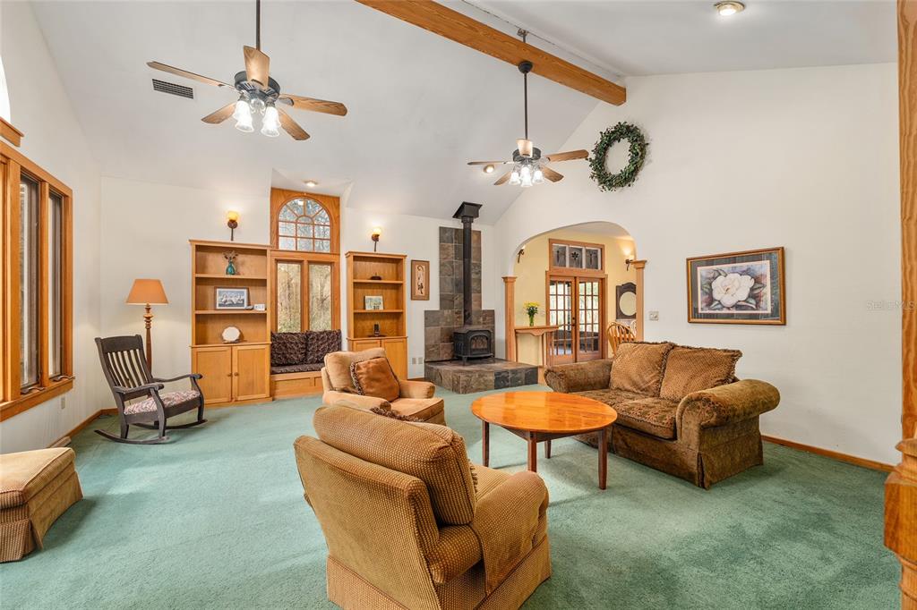 21736 Northwest 75th Avenue Road Micanopy, FL 32667 - Photo 17 of 88 a living room with furniture a clock and a large window