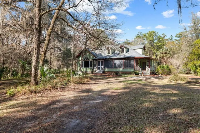 a view of a house with a small yard plants and large tree
