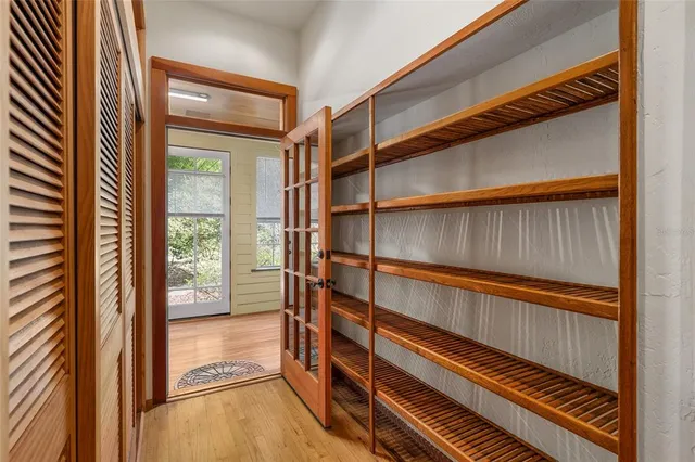 a view of a hallway with wooden floor and furniture