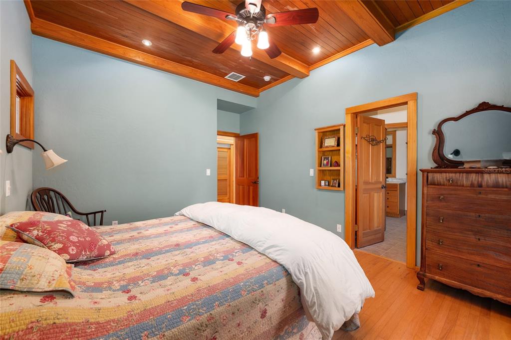 21736 Northwest 75th Avenue Road Micanopy, FL 32667 - Photo 40 of 88 a bedroom with a bed and a dresser with wooden floor