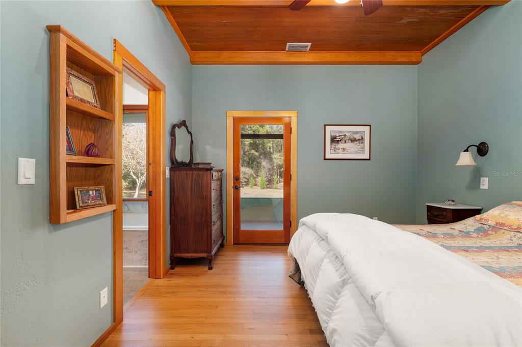 21736 Northwest 75th Avenue Road Micanopy, FL 32667 - Photo 41 of 88 a bedroom with a bed and a painting on the wall