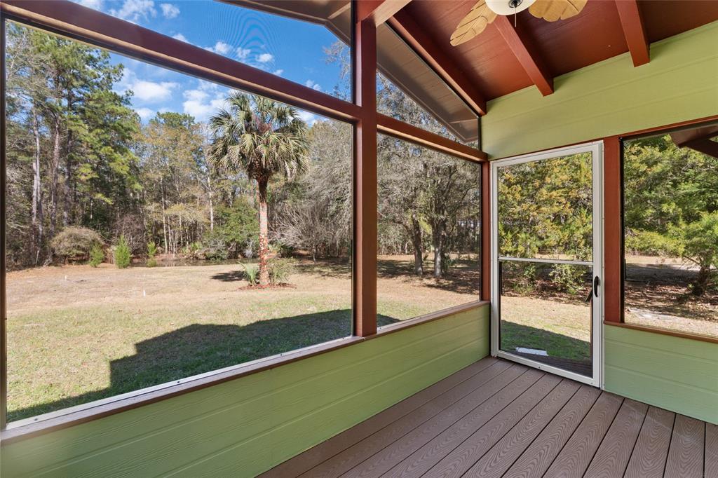 21736 Northwest 75th Avenue Road Micanopy, FL 32667 - Photo 42 of 88 a view of a room with wooden floor and a floor to ceiling window