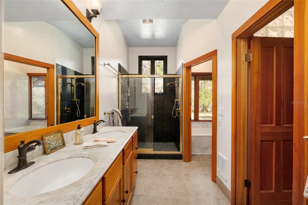 21736 Northwest 75th Avenue Road Micanopy, FL 32667 - Photo 44 of 88 a bathroom with a double vanity sink and a mirror
