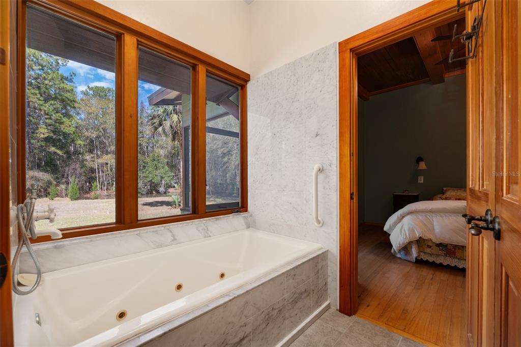 21736 Northwest 75th Avenue Road Micanopy, FL 32667 - Photo 47 of 88 a bathroom with a tub and a window
