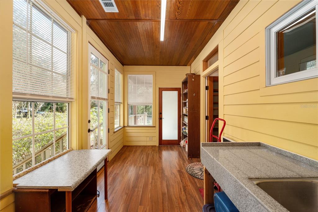 21736 Northwest 75th Avenue Road Micanopy, FL 32667 - Photo 69 of 88 a view of a hallway with wooden floor and furniture