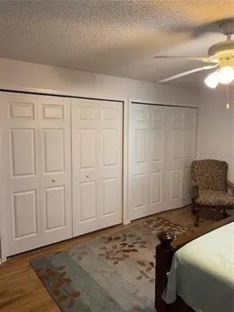 a bedroom with a large bed and a chandelier fan