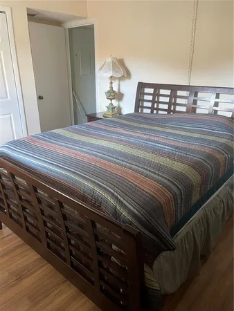 a bedroom with a bed a mirror and lamp