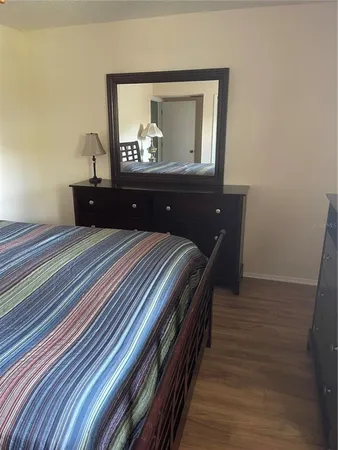 a bedroom with a bed and a mirror on dresser