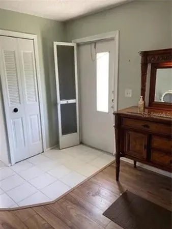 a workspace room with wooden floor windows and furniture