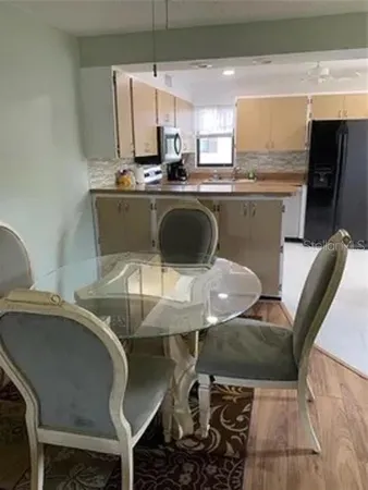 a kitchen with a table chairs sink and cabinets