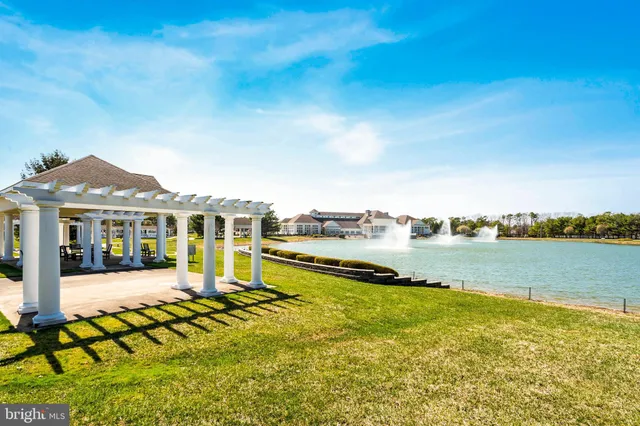 an aerial view of a residential houses with outdoor space and a lake view